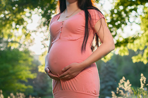 Pregnant woman holding stomach 500px