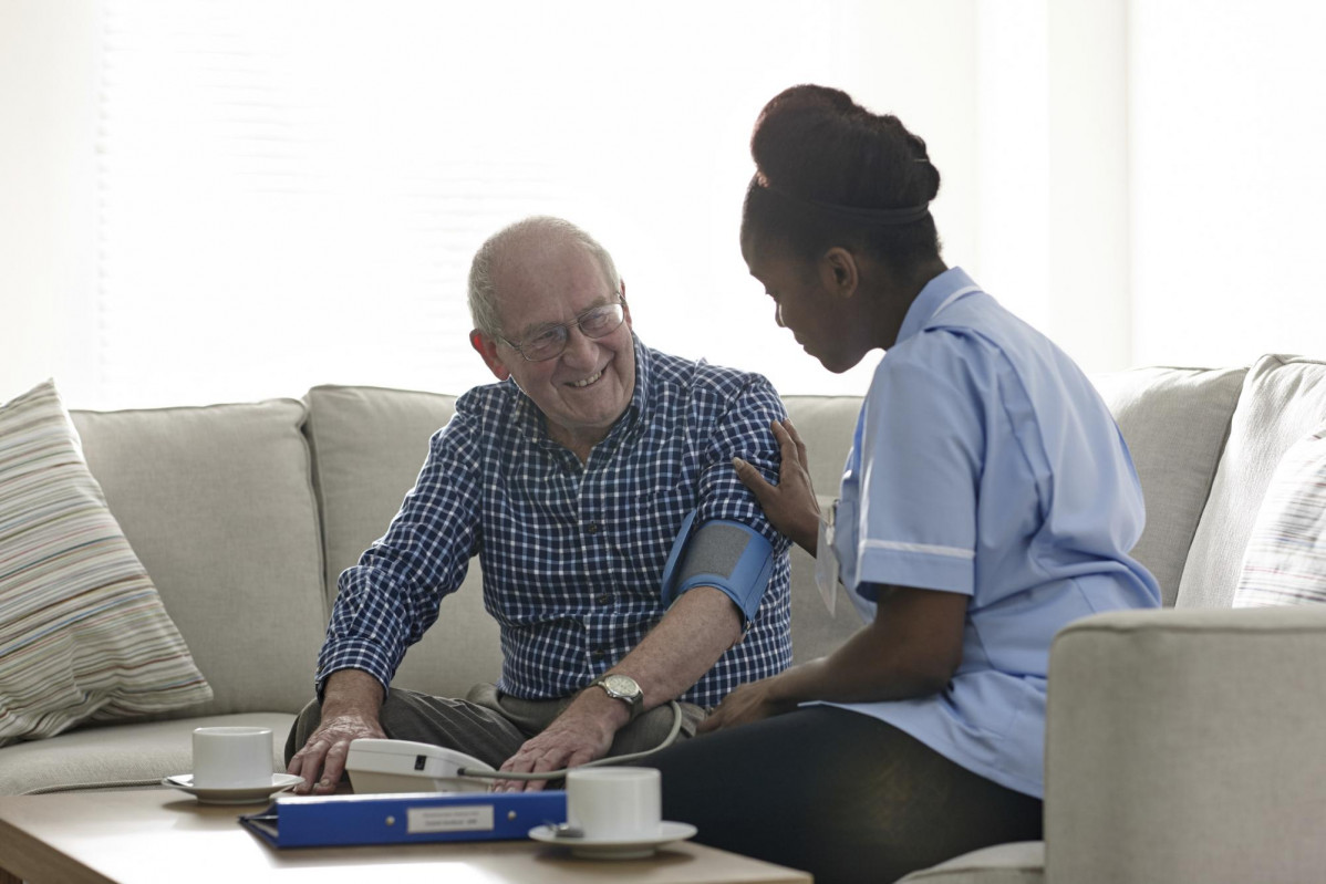 Home nurse checking patients blood pressure 000055925418 Large