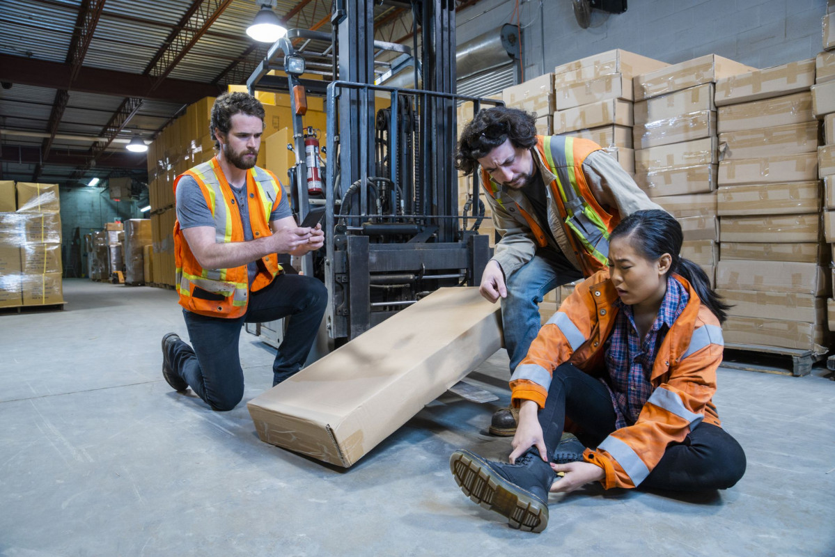 An industrial warehouse workplace safety topic  a worker injured falling or being struck by a forklift  1163443516 7409310367d9438b91d3e0e057ff118e