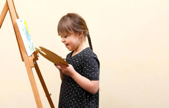 Side view of happy girl with down syndrome painting 16022306 20210321151309