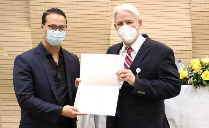 El doctor Jorge Marte entrega certificado a uno de los doctores. 696x429