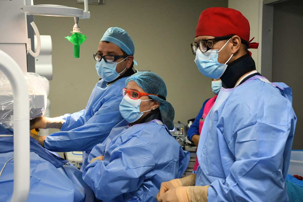 Dra. Eliany Mejia Lopez junto al Dres. Alan Jhonson y Alfred Walker realizando procedimiento quirurgico a pacientes de escasos recur 1024x683